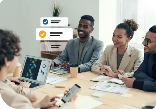 Fünf Personen sitzen an Tisch mit Laptops, Notizblöcken und Kaffeebechern; auf einem Laptop sind Codezeilen und Daten sichtbar.